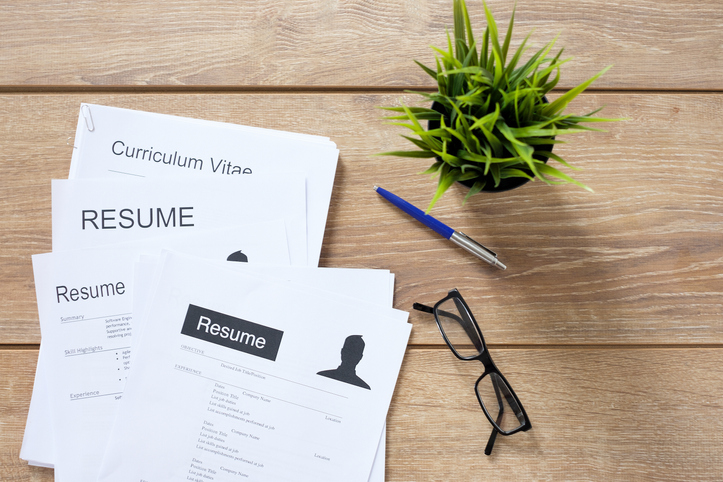 Resume applications on wooden desk ready to be reviewed