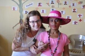 Mercy Ships nurse with a patient in pink with a hat
