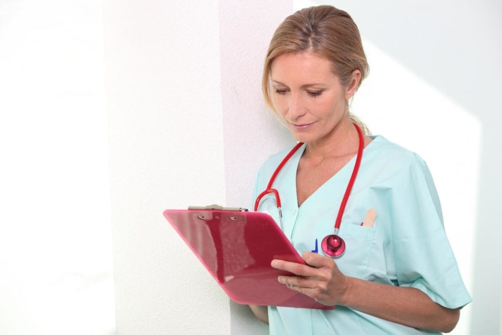 travel nurse looking at clipboard