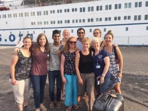 volunteer travel nurses in front of Mercy Ships in Benin Africa