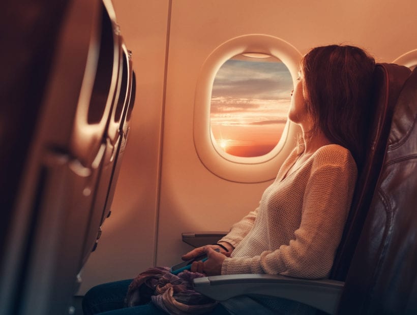 Woman in airplane looking through the window