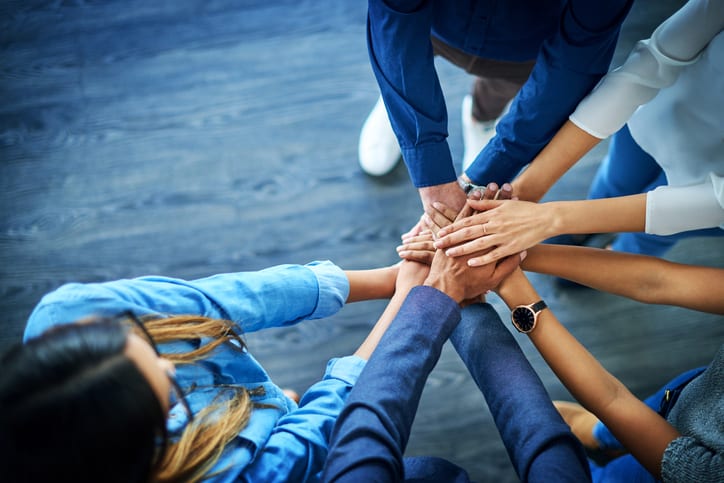 Diverse group of nurses joining hands in unity
