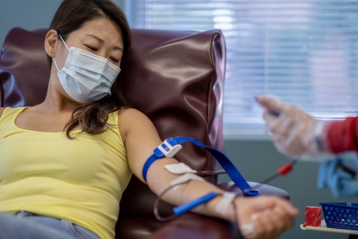 Masked Asian woman at a blood donation drive