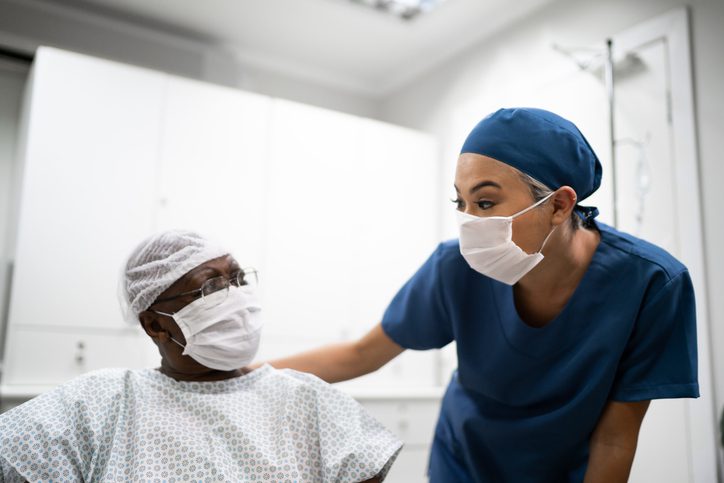 Nurse talking and doing a emotional support to a female senior patient at hospital