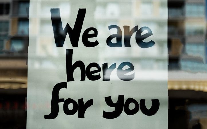 We Are Here For You Sign on Window of Business