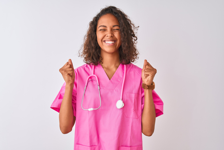 Young brazilian nurse woman wearing stethoscope standing over isolated white background excited for success with arms raised and eyes closed celebrating victory smiling. Winner concept.