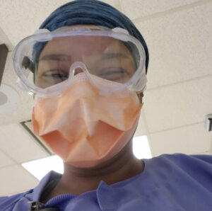 Chelsie in scrubs, mask, and eye protection