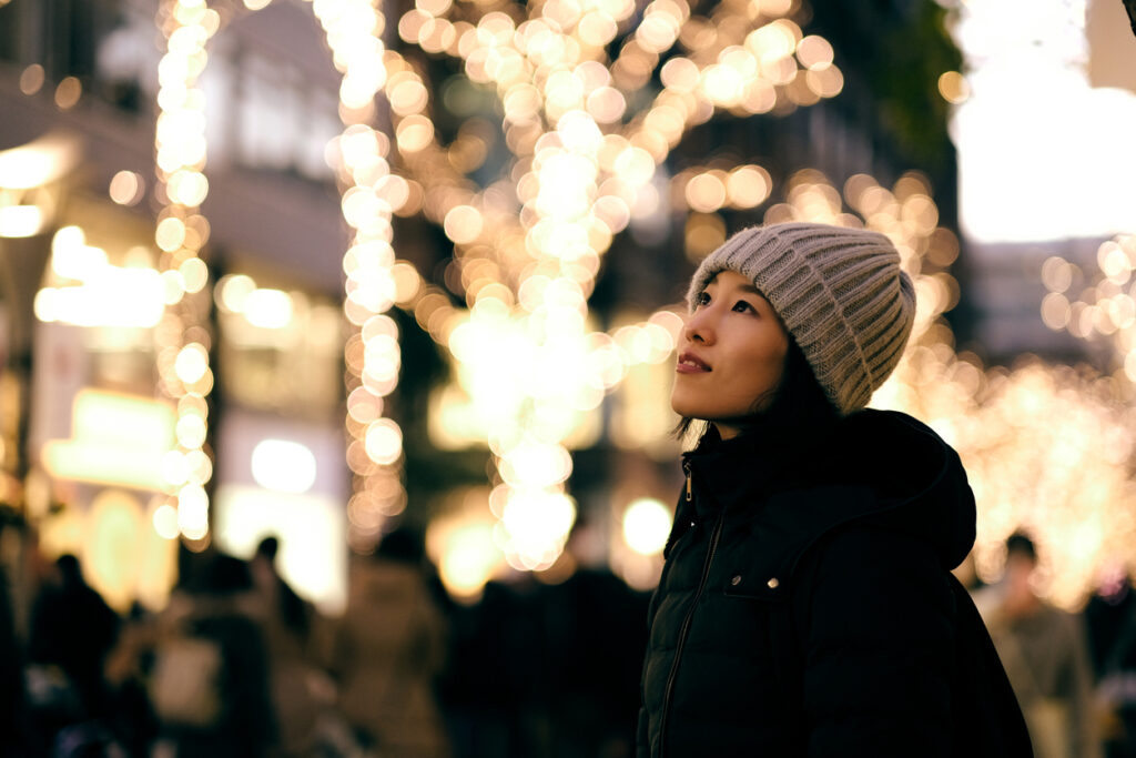 Young woman looking at illuminated city of December