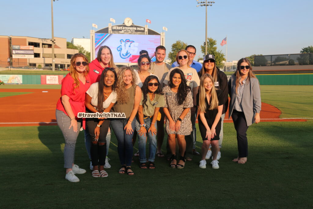 group of TNAA employees and travelers at the Dickey Stephens Park for a baseball game