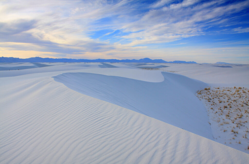 Expansive white gypsum sand dunes under a bright blue sky at White Sands National Park, New Mexico